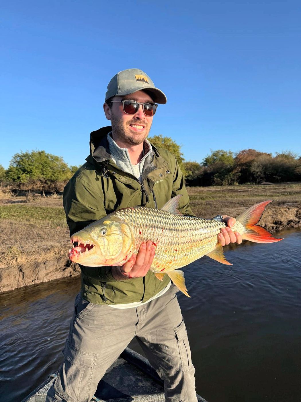 Client holding a tigerfish on the river