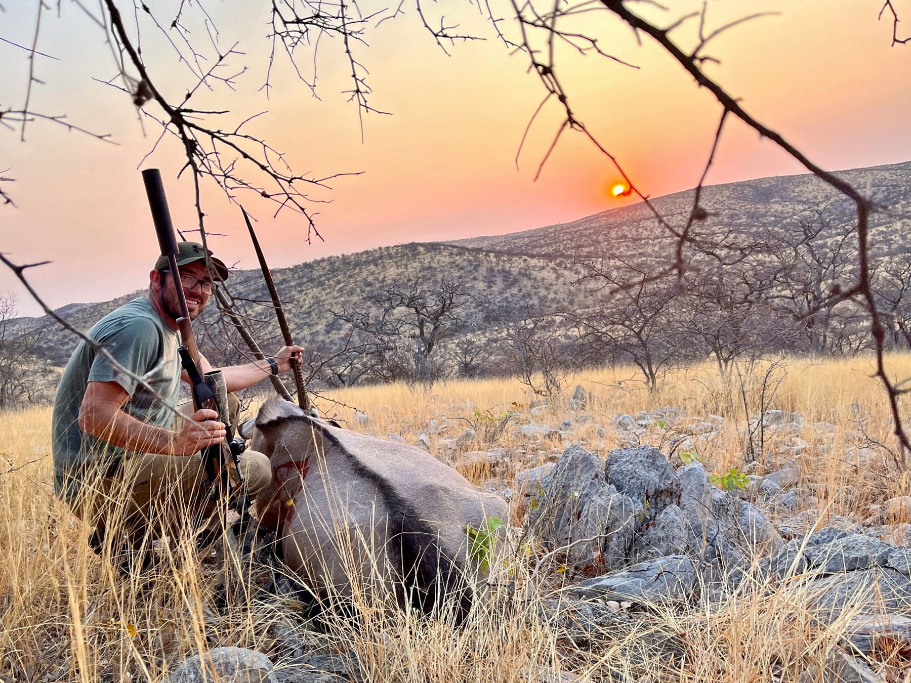 Hunter with a gemsbok at sunset